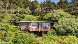 a house in the middle of a forest at Sunset Cove by AvantStay Beachfront w Balcony in Arch Cape