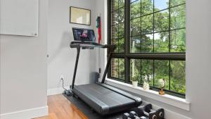ein Fitnessstudio mit Laufband in einem Raum mit Fenster in der Unterkunft Modern Chic Fishtown-Philly Home with Roof Deck in Philadelphia