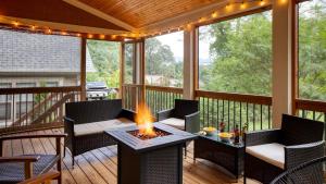 a screened porch with a fire pit on a deck at Sweetgum by AvantStay Black Mountain Retreat w Covered Deck in Black Mountain