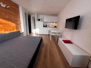 a living room with a couch and a kitchen at Matterhorn Studio Cervinia in Breuil-Cervinia