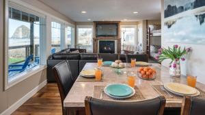 a dining room with a table and a couch at Blue Starfish by AvantStay Ocean Views Direct Cannon Beach Access in Cannon Beach