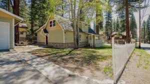 a yellow house with a fence in front of it at Aster by AvantStay Classic Kings Beach Cottage In The Of North Shore in Kings Beach