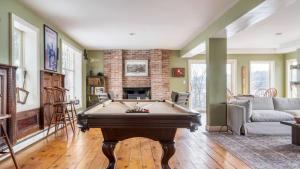 a living room with a pool table in it at River House by AvantStay Historic Secluded Estate on the Hudson River w Pool Sleeps 24 in Hudson