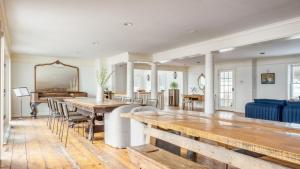 a living room with wooden tables and a blue couch at River House by AvantStay Historic Secluded Estate on the Hudson River w Pool Sleeps 24 in Hudson