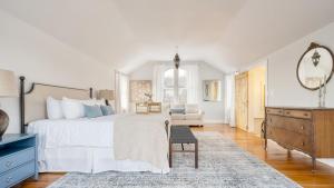 a white bedroom with a large bed and a chair at River House by AvantStay Historic Secluded Estate on the Hudson River w Pool Sleeps 24 in Hudson +50 photos