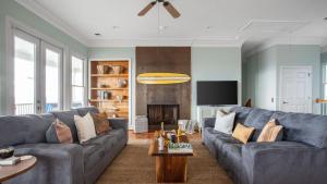 a living room with a blue couch and a tv at Poseidon By AvantStay On The Beach Two Ocean Facing Balconies Hot Tub in Folly Beach