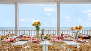 a table with food and the ocean in the background at Poseidon By AvantStay On The Beach Two Ocean Facing Balconies Hot Tub in Folly Beach