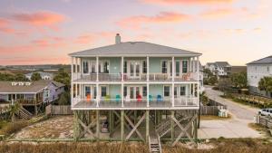 a house with a wrap around porch on a beach at Poseidon By AvantStay On The Beach Two Ocean Facing Balconies Hot Tub in Folly Beach