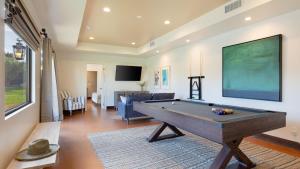 a living room with a pool table in it at Sleeps 20 Architectural Mansion w Pool Indoor Tennis Court Game Room Starlight Estate by AvantStay in Bermuda Dunes