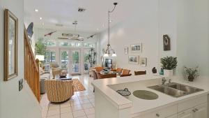 a kitchen with a sink and a living room at Key West Found by AvantStay Close to Shops w Patio Shared Pool Week Long Stays Only in Key West