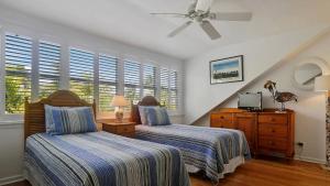 a bedroom with two beds and a ceiling fan at Key West Found by AvantStay Close to Shops w Patio Shared Pool Week Long Stays Only in Key West +20 photos