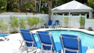 a group of blue chairs sitting next to a pool at Key West Found by AvantStay Close to Shops w Patio Shared Pool Week Long Stays Only in Key West