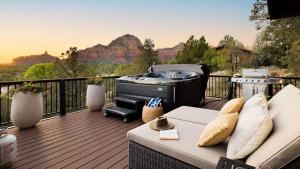 a patio with a grill and a couch on a deck at Roca Roja by AvantStay Mountain Views in the Heart of Sedona in Sedona
