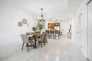 Luxury Condo Retreat in Merritt Island RFI-1004 في Audubon: غرفة طعام ومطبخ مع طاولة وكراسي