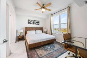 Luxury Condo Retreat in Merritt Island RFI-1004 في Audubon: غرفة نوم مع سرير مع مروحة سقف ونافذة