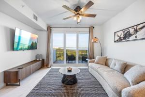 Luxury Condo Retreat in Merritt Island RFI-1004 في Audubon: غرفة معيشة مع أريكة ومروحة سقف