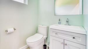 a white bathroom with a toilet and a sink at Beach Pines Bungalow by AvantStay Classic Cottage Steps to the Beach w Private Yard in Arch Cape +21 photos