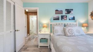 a bedroom with a white bed with a white bedside table at Beach Pines Bungalow by AvantStay Classic Cottage Steps to the Beach w Private Yard in Arch Cape