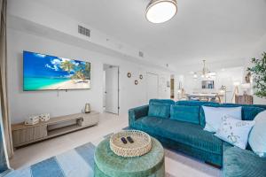 RIVER FLY IN Luxury Condo 2BR w Huge Balcony RFI-305 في Audubon: غرفة معيشة مع أريكة زرقاء وتلفزيون