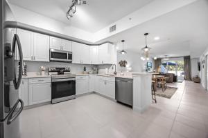 RIVER FLY IN Luxury Condo 2BR w Huge Balcony RFI-305 في Audubon: مطبخ بخزائن بيضاء وأجهزة سوداء