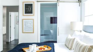 a bedroom with a tray of fruit on a white couch at ONeill I by AvantStay Coastal Paradise Steps from Beach Modern Decor in Newport Beach