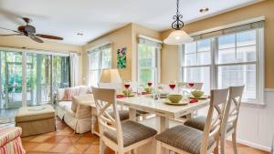 Cottage by the Pool by AvantStay w Balcony BBQ Shared Pool Month Long Stays Only في ستوك آيلاند: غرفة طعام مع طاولة بيضاء وكراسي