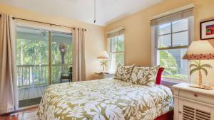 Cottage by the Pool by AvantStay w Balcony BBQ Shared Pool Month Long Stays Only في ستوك آيلاند: غرفة نوم بها سرير ونوافذ كبيرة