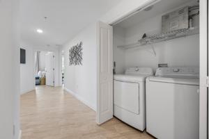 a white laundry room with two washing machines in it at Luxury Condo with Sanctuary Views Merritt Island in Audubon