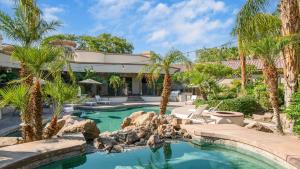 a swimming pool with palm trees in a yard at Villa Verbena by AvantStay Expansive Estate w B-ball Court PoolSpa Entertainers Yard in Bermuda Dunes