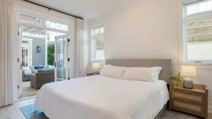 um quarto branco com uma cama e uma sala de estar em Emerald Cove by AvantStay Mins to Beach Pier em Newport Beach