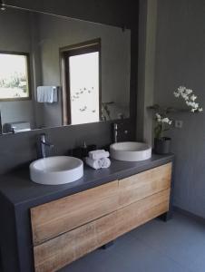 a bathroom with two sinks and a large mirror at Ju'Blu Hotel in Lovina
