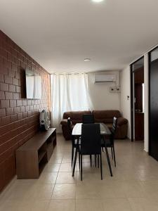 a living room with a table and chairs and a couch at Departamento Villas Doradas in Santa Cruz Huatulco