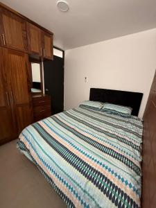 a bedroom with a bed with a striped comforter at Departamento Villas Doradas in Santa Cruz Huatulco