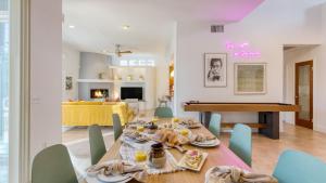 a dining room and living room with a table and chairs at Pool Hot Tub Yard Games Chic Midcentury Design Painted Sand by AvantStay in Bermuda Dunes