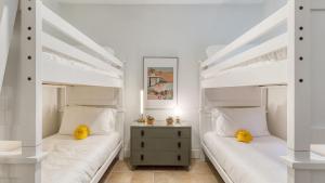 two twin beds in a bedroom with white walls at Pool Hot Tub Yard Games Chic Midcentury Design Painted Sand by AvantStay in Bermuda Dunes