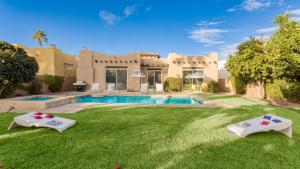 a house with a yard with a swimming pool at Pool Hot Tub Yard Games Chic Midcentury Design Painted Sand by AvantStay in Bermuda Dunes