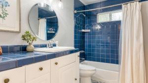 a blue tiled bathroom with a sink and a toilet at North Bay by AvantStay Chic Retreat w Peloton in Blue Jay +29 photos