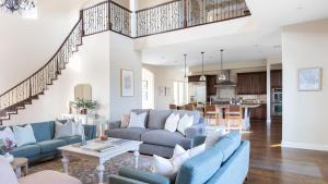 a living room with blue couches and a kitchen at Palazzo Del Sol By AvantStay Breathtaking Home w Mountain Views Hot Tub in Temecula