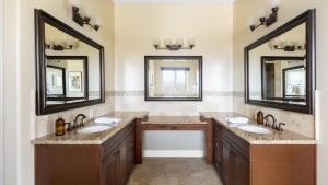 a bathroom with two sinks and two mirrors at Palazzo Del Sol By AvantStay Breathtaking Home w Mountain Views Hot Tub in Temecula +41 photos