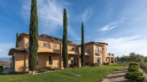 a row of cypress trees in front of a building at Palazzo Del Sol By AvantStay Breathtaking Home w Mountain Views Hot Tub in Temecula