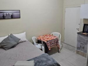 コチアにあるKitnet em Cotia perto Animalia Park CT do Sao Pauloのテーブルと椅子2脚とベッドのある寝室 +16枚の写真