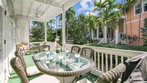 Coral Palm by AvantStay Key West Walkable Gated Community Shared Pool في ستوك آيلاند: فناء في الهواء الطلق مع طاولة وكراسي