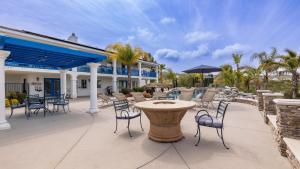 eine Terrasse mit Stühlen und einem Tisch und einem Gebäude in der Unterkunft Le Grand Bleu by AvantStay Luxury Hilltop Estate in Temecula