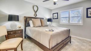 a bedroom with a bed and a chair and a window at Dune Wind South by AvantStay Communal Pool Hot Tub Gated Community Close to Smathers Beach Month Long Stays Only in Key West +22 photos