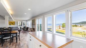 a kitchen and dining room with a view of the ocean at Private Beach Access Water Views Sleeps 18 Historic 6BDR Farmhouse w Deck in Clinton