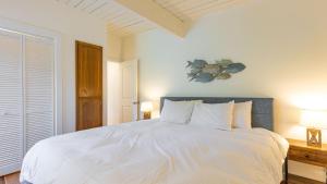 a bedroom with a large white bed with two lamps at Sunny Side Island Retreat by AvantStay Backyard in Freeland