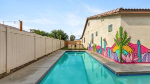 a swimming pool with a mural on the side of a building at Kaleidoscope by AvantStay Colorful Escape Pool in Indio