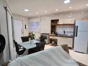 a kitchen and dining room with a table and a refrigerator at Apartamento 8min da praia e 11 do Beto Carrero in Penha +6 photos