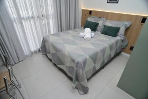 a teddy bear sitting on a bed in a bedroom at Green One - Em Frente à Estação Luz com varanda e vaga rotativa in São Paulo