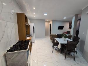 a kitchen and dining room with a table and a stove at Apartamento 8min da praia e 11 do Beto Carrero in Penha